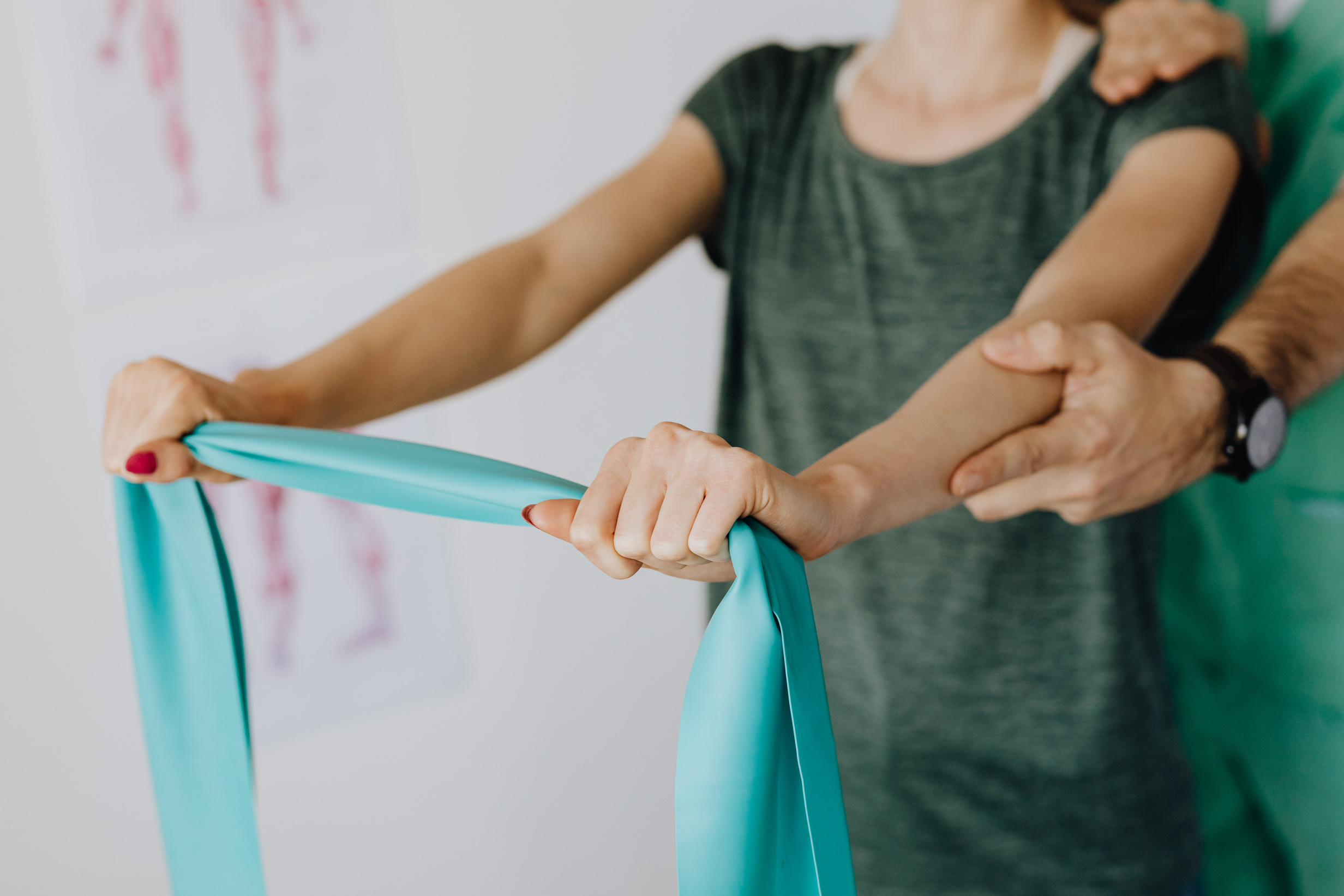 Crop anonymous woman stretching elastic band near professional chiropractor