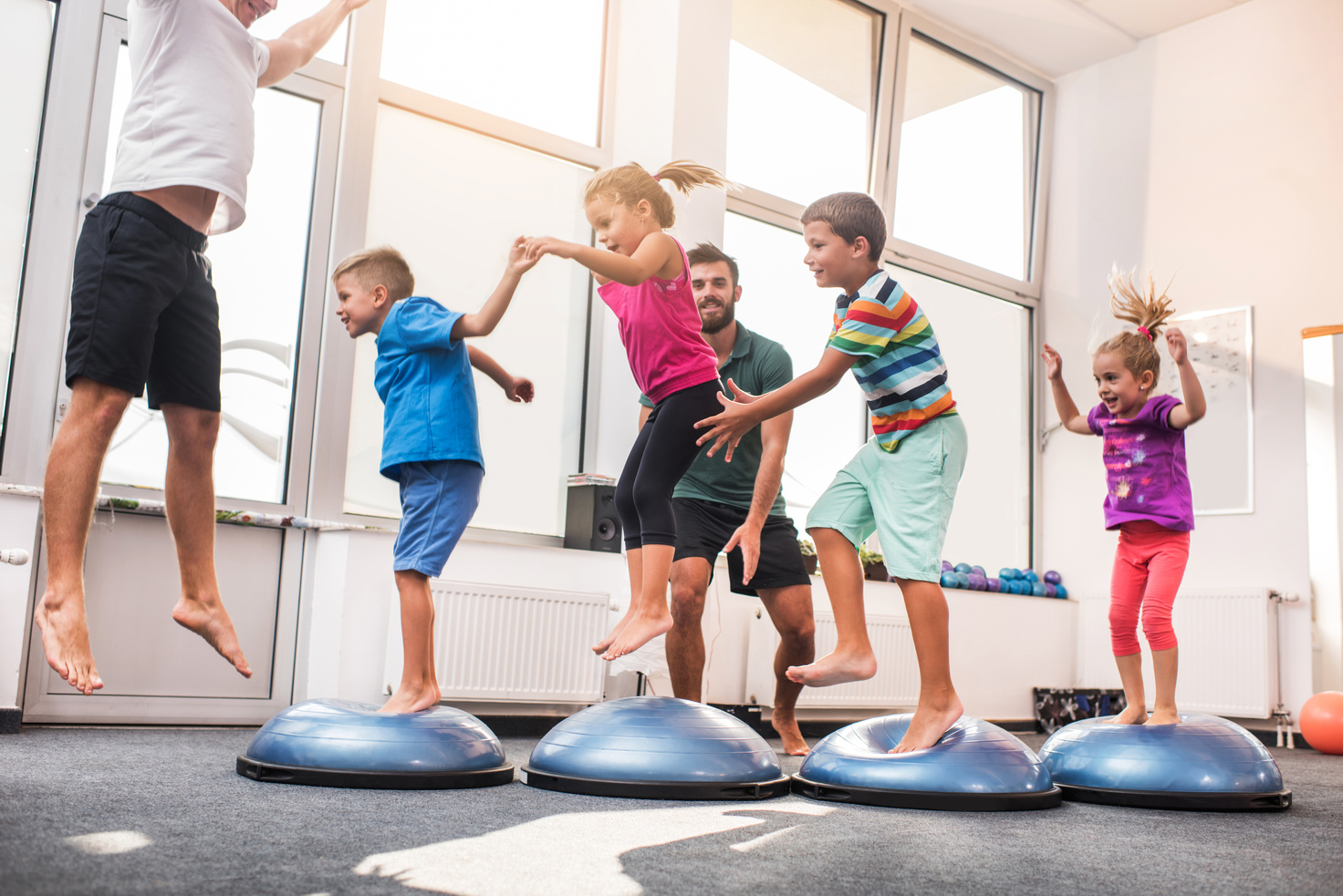 Small children jumping on bosu balls on training class.